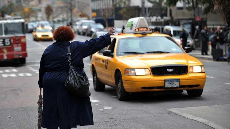 A woman tries to hail a taxi on First Avenue...