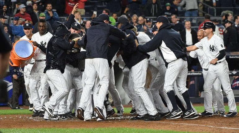 New York Yankees players mob Mark Teixeira at home plate...