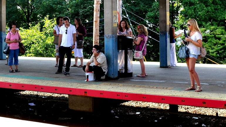 Passengers wait for a westbound LIRR train at the Hicksville...