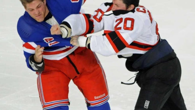 New Jersey Devils' Ryan Carter, right, fights with New York...