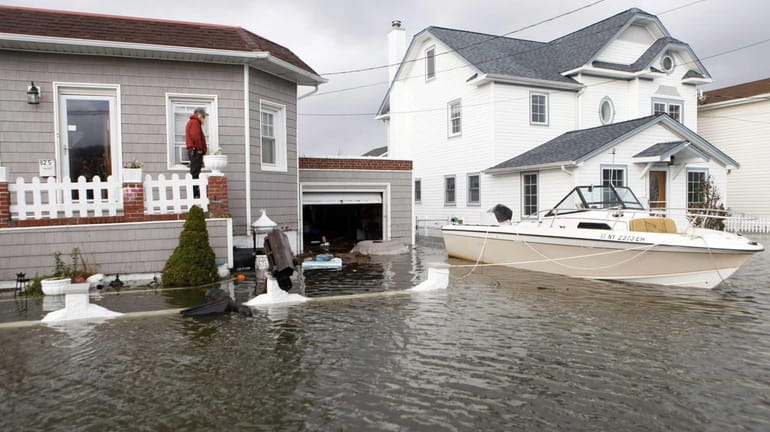 A boat floats in the driveway of a Lindenhurst home...