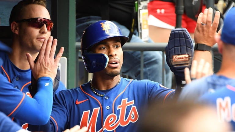 New York Mets' Francisco Lindor is greeted in the dugout...