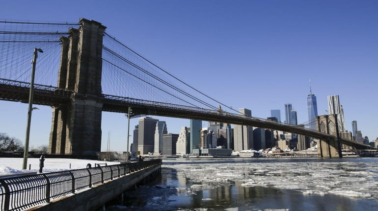 Ice floats along the East River under the Brooklyn Bridge.
