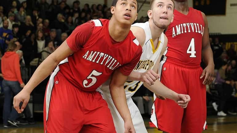 Amityville's Mike Smith boxes out Northport's Andrew Seaman in the...