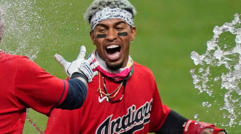 Cleveland's Francisco Lindor, right, tosses water on Jose Ramirez after...