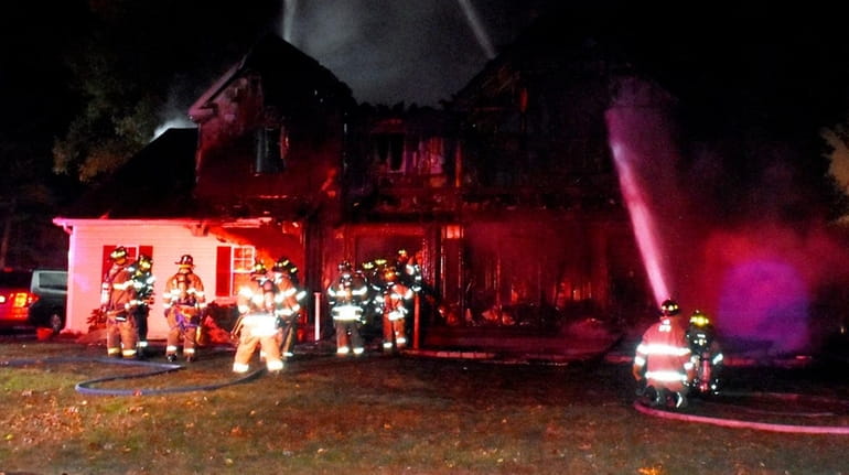 Firefighters battle a blaze that gutted a house in Centereach...