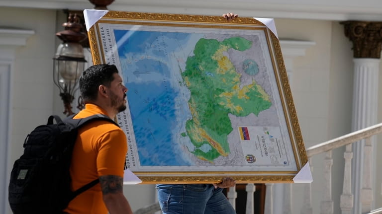 A man carries the new map of Venezuela with the...