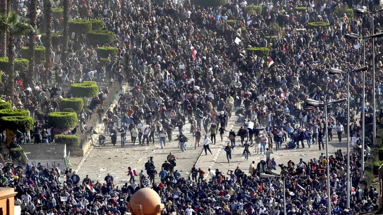 Pro-government demonstrators, bottom, clash with anti-government demonstrators, top, in Tahrir...