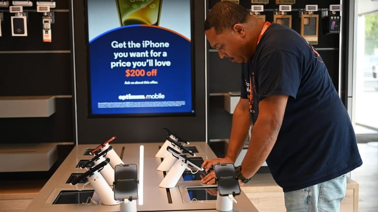 A customer checks out phones at the new Optimum store in...