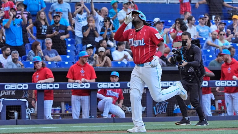 Miami Marlins' Josh Bell celebrates as he heads to home...