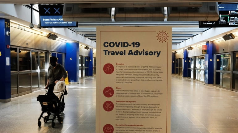 COVID-19 information is displayed at an international terminal at Kennedy...