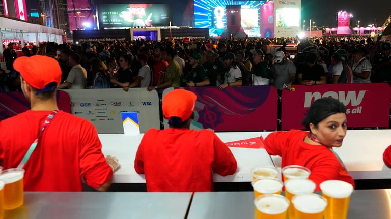 FILE - Fans wait in line for beer at a...