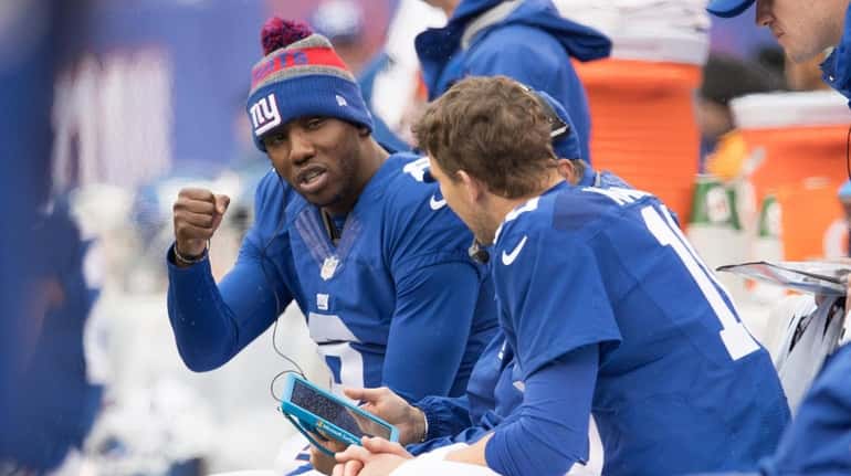 New York Giants quarterback Eli Manning (10) confers with teammate...