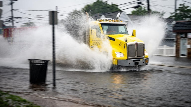A truck makes its way through a flooded Wellwood Avenue in Lindenhurst...