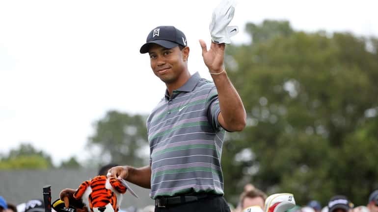 Tiger Woods waves to the gallery on the first tee...