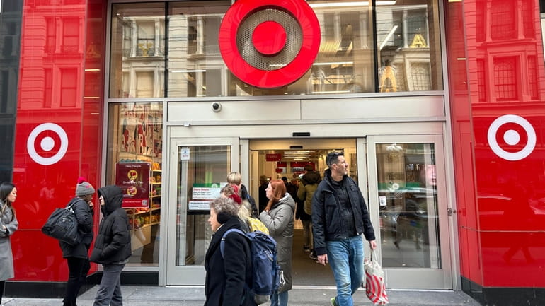 Shoppers walk from a Target store in midtown Manhattan in...