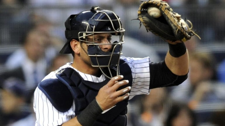 Yankees catcher Francisco Cervelli handles a pitch from Phil Hughes...