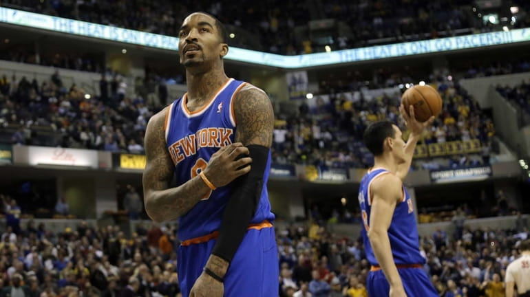 Knicks guard J.R. Smith looks at the scoreboard as he...