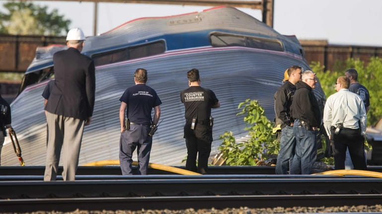 Authorities look at the scene of the Amtrak train derailment...