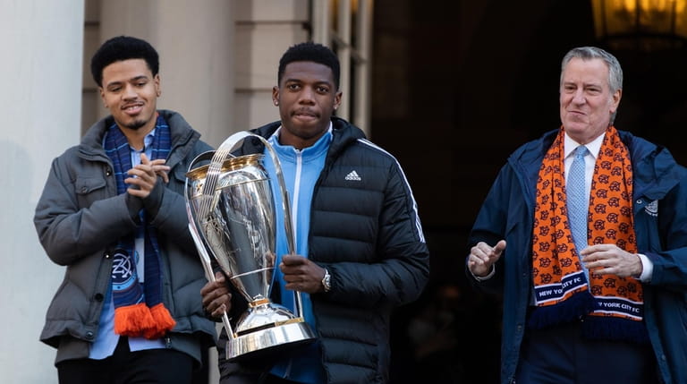 NYCFC captain Sean Johnson (center) carries the Philip F. Anschutz Trophy...