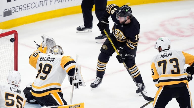 Boston Bruins' Pavel Zacha (18) scores on Pittsburgh Penguins' Alex...