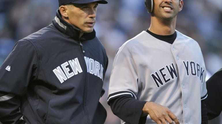 New York Yankees catcher Jorge Posada, right, walks with manager...