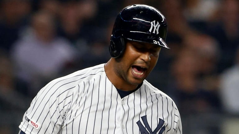 Yankees outfiedler Aaron Hicks reacts after he was called out...