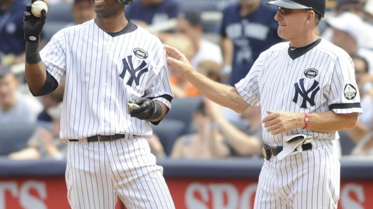 New York Yankees' Eduardo Nunez, left, holds the ball that...