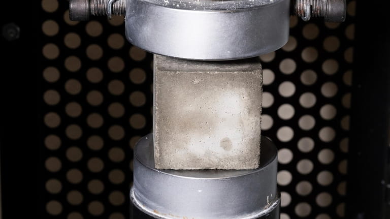 A mortar cube is tested for compressive strength in the...
