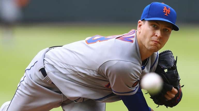 Mets pitcher Jacob deGrom throws against the Braves during the...