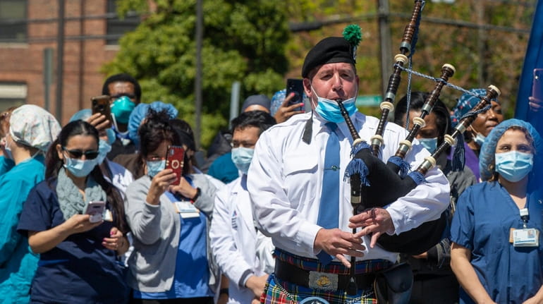 The Nassau County Police Department Emerald Society Pipe Band plays to...