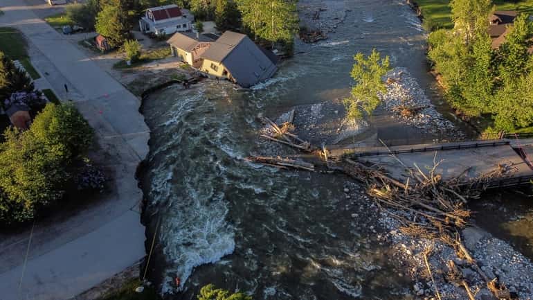 A house sits in Rock Creek after floodwaters washed away...