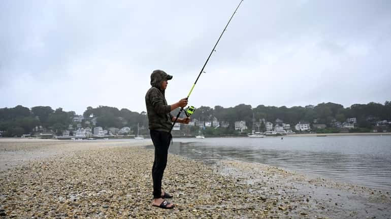 Gerardo Mejilla, 25, of Centerport, fishes on a gray and...