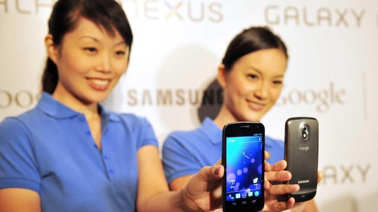 Models hold the new Samsung Galaxy Nexus Android phone during...