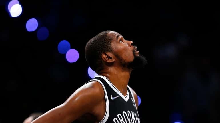 Nets forward Kevin Durant looks at the score board during...