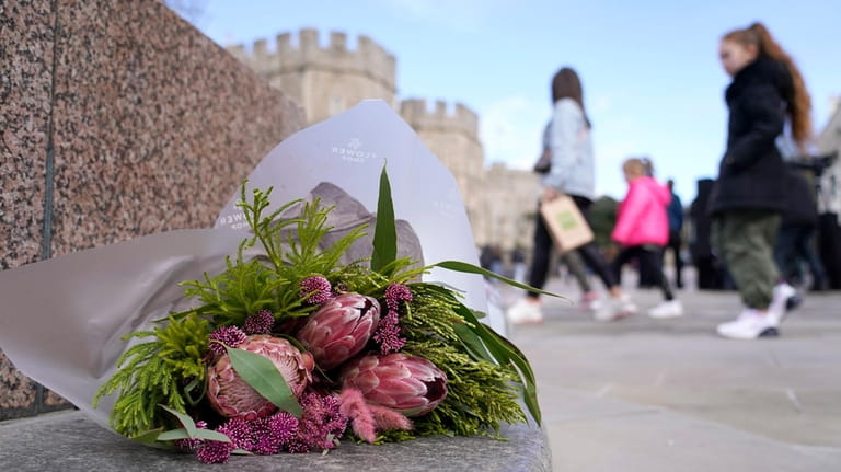 Flowers are left outside Windsor Castle in Windsor, England, Saturday,...