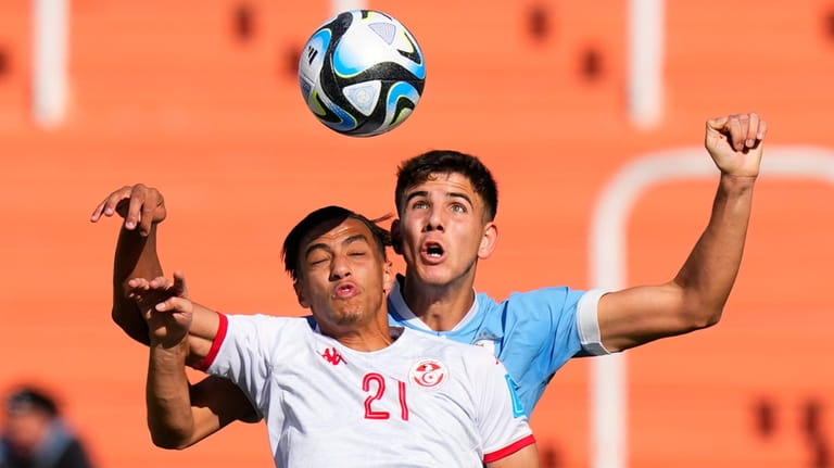 Uruguay's Facundo Gonzalez, right, and Tunisia's Jebril Othman go for...