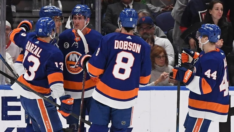 Islanders players celebrate a power-play goal by center Brock Nelson...