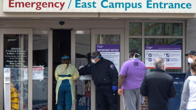 Health care workers outside the emergency room at NYU Winthrop...