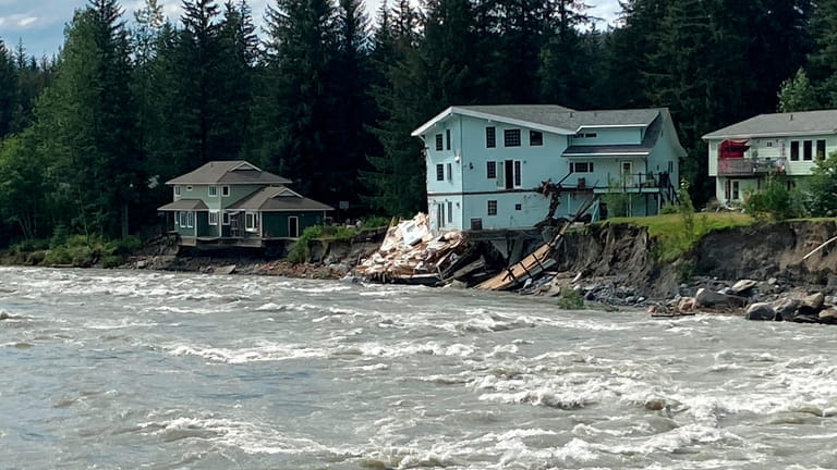 The swollen Mendenhall River courses along a neighborhood in Juneau,...