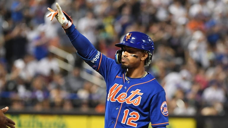Mets' Francisco Lindor gestures to the dugout after his two-run...