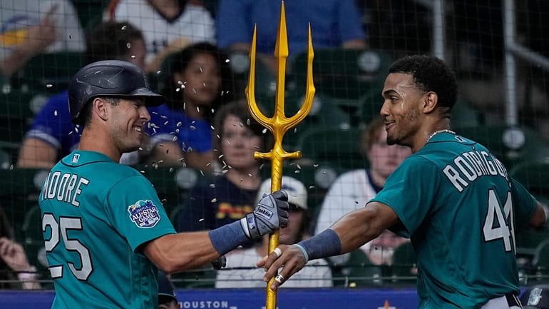 Seattle Mariners' Dylan Moore (25) is presented with a trident...