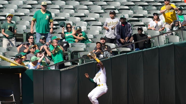 Fans watch as Oakland Athletics left fielder Esteury Ruiz catches...