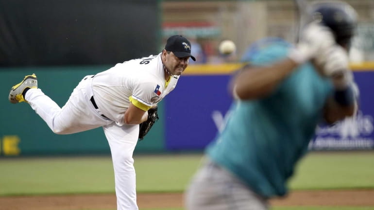 Sugar Land Skeeters' Roger Clemens, left, throws a pitch to...