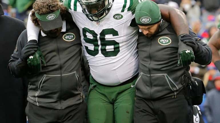 Muhammad Wilkerson is helped off the field after breaking his...
