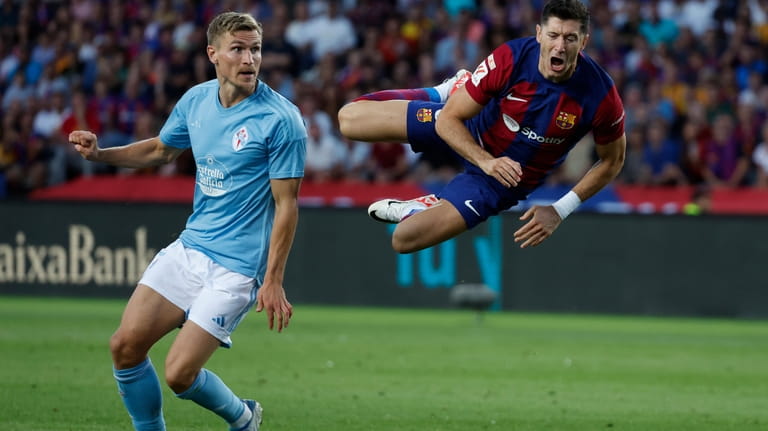 Barcelona's Robert Lewandowski, right, flies through the air after a...
