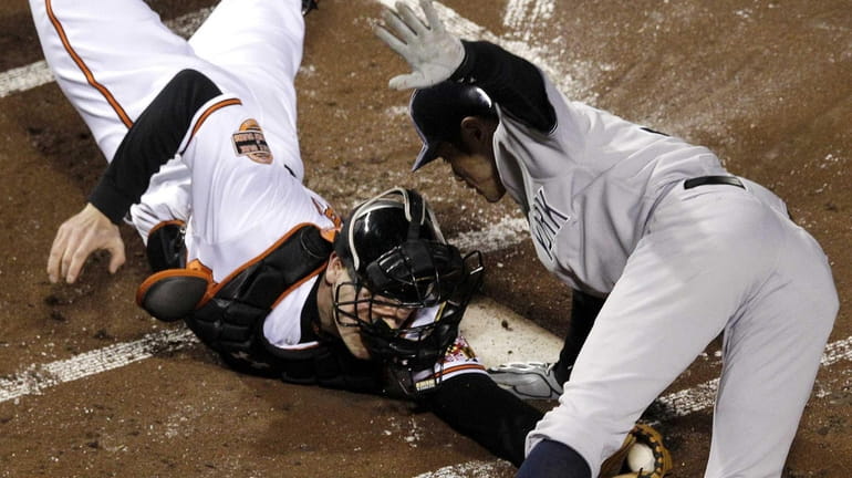 Ichiro Suzuki leaps past Baltimore Orioles catcher Matt Wieters to...