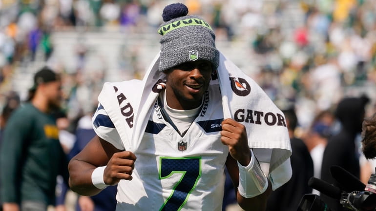 Seattle Seahawks quarterback Geno Smith runs off the field after...