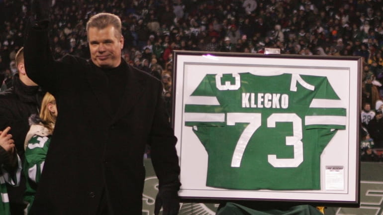 Former Jets defensive lineman Joe Klecko, left, gets his jersey...