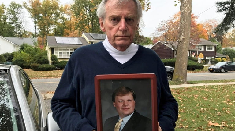 Jimmy Drake, 73, holds a photo of his son, Darren...